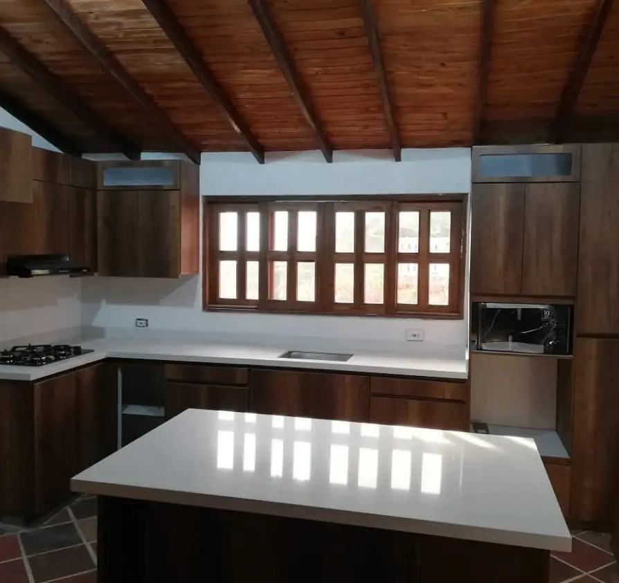 Cocina en madera con techo en vigas e isla
