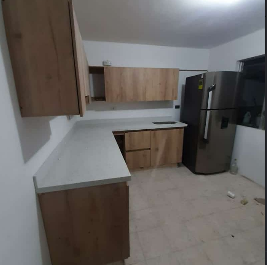 Cocina con mesón en mármol y gabinetes en madera